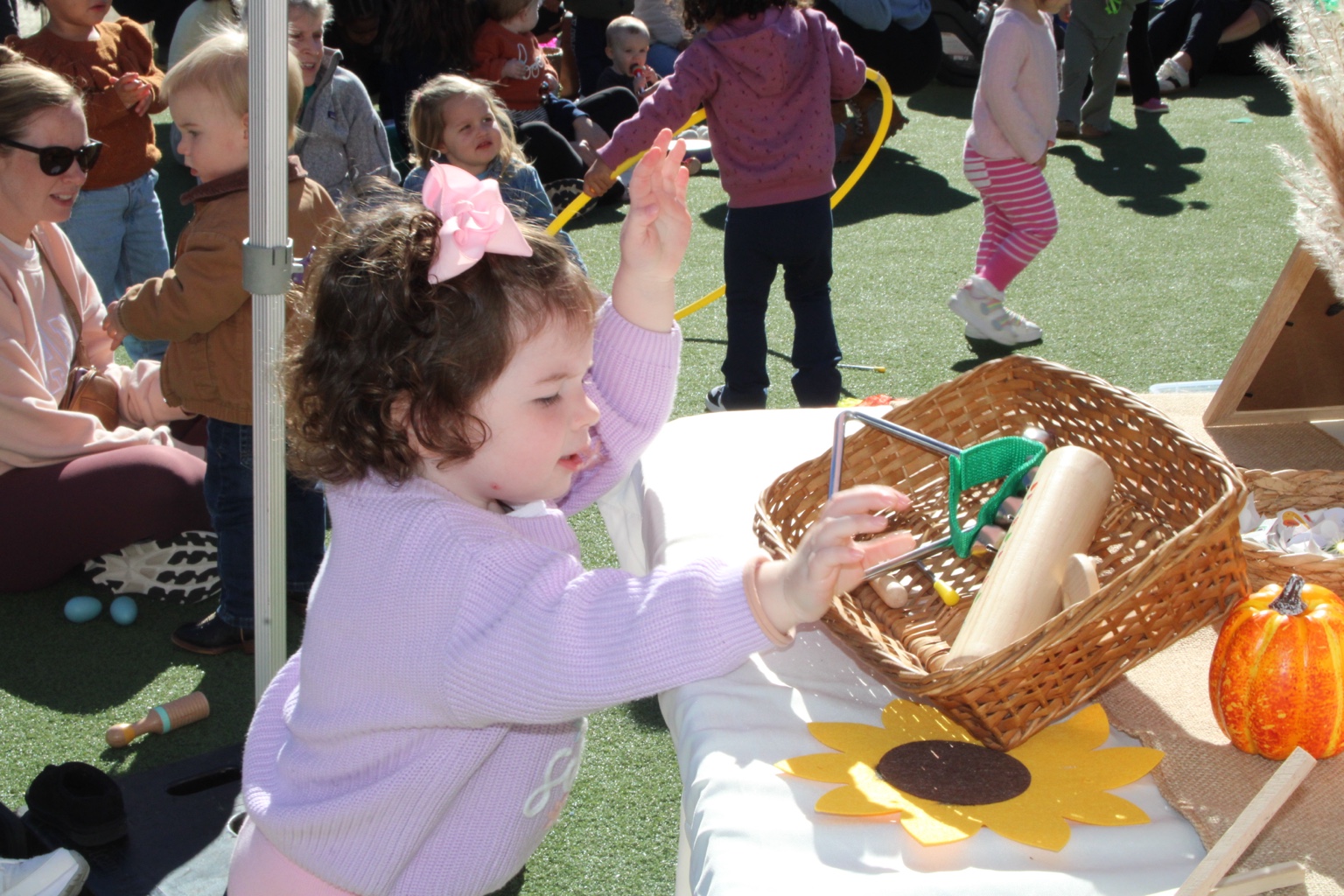 Exploring instruments together at an outdoor music event.