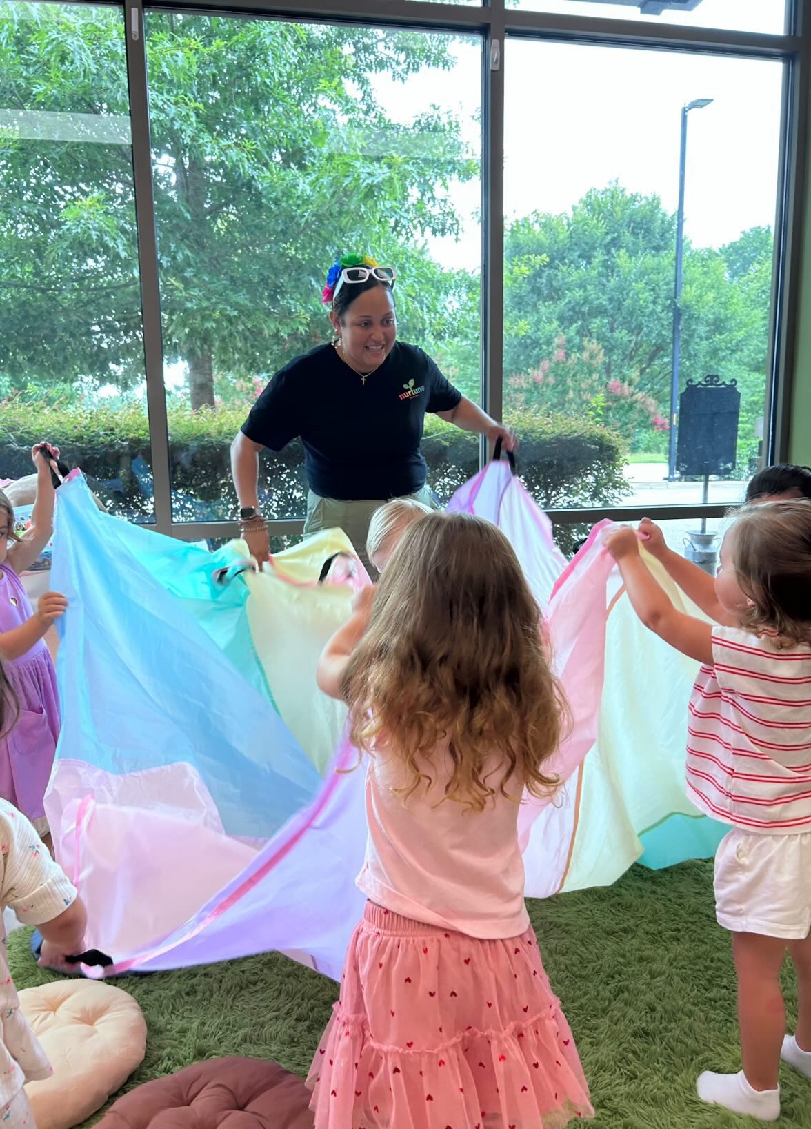Janessa leading children in a colorful Nurtune Music parachute activity